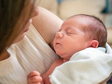 Neugeborenes im Arm seiner Mutter
